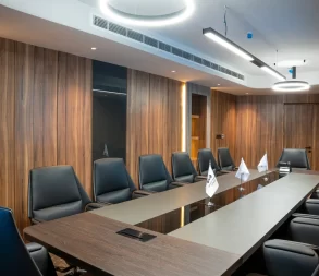 Elegant meeting space featuring comfortable black leather chairs and contemporary lighting.