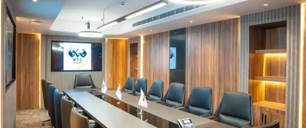 Modern conference room with leather chairs and digital display.