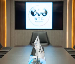 Modern conference room with world trade logo display and seating arrangement.