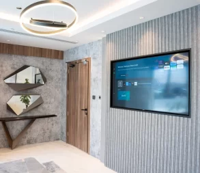 Stylish lounge space at WTC Riyadh with decorative walls, modern lighting, and smart TV.