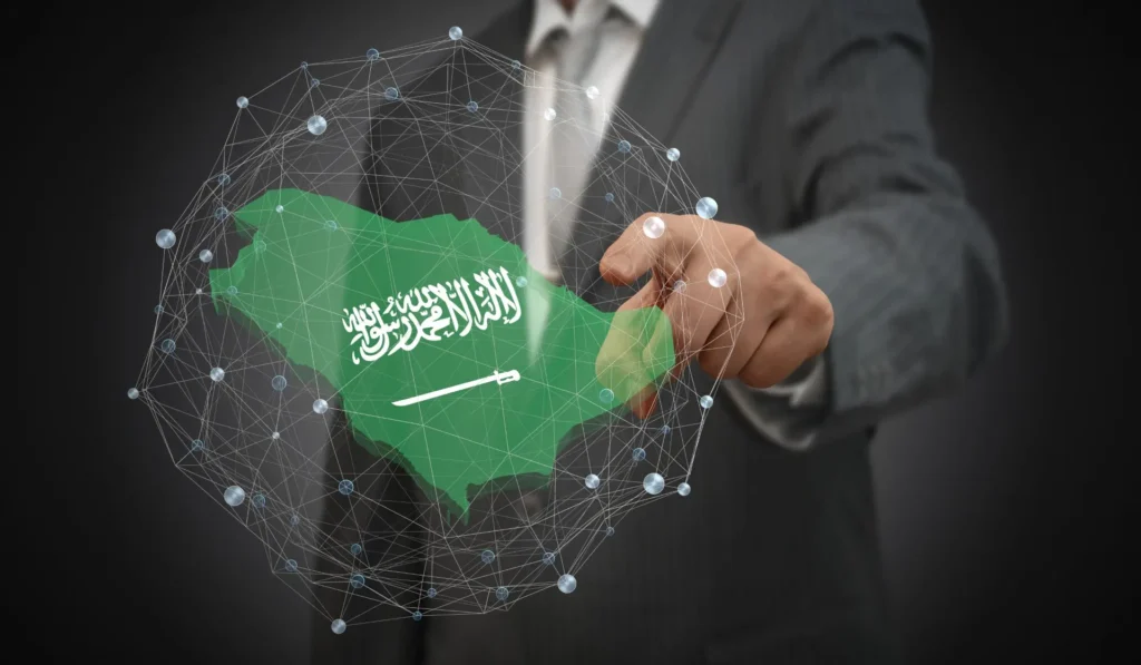 Close-up of a hand pointing to a map of Saudi Arabia